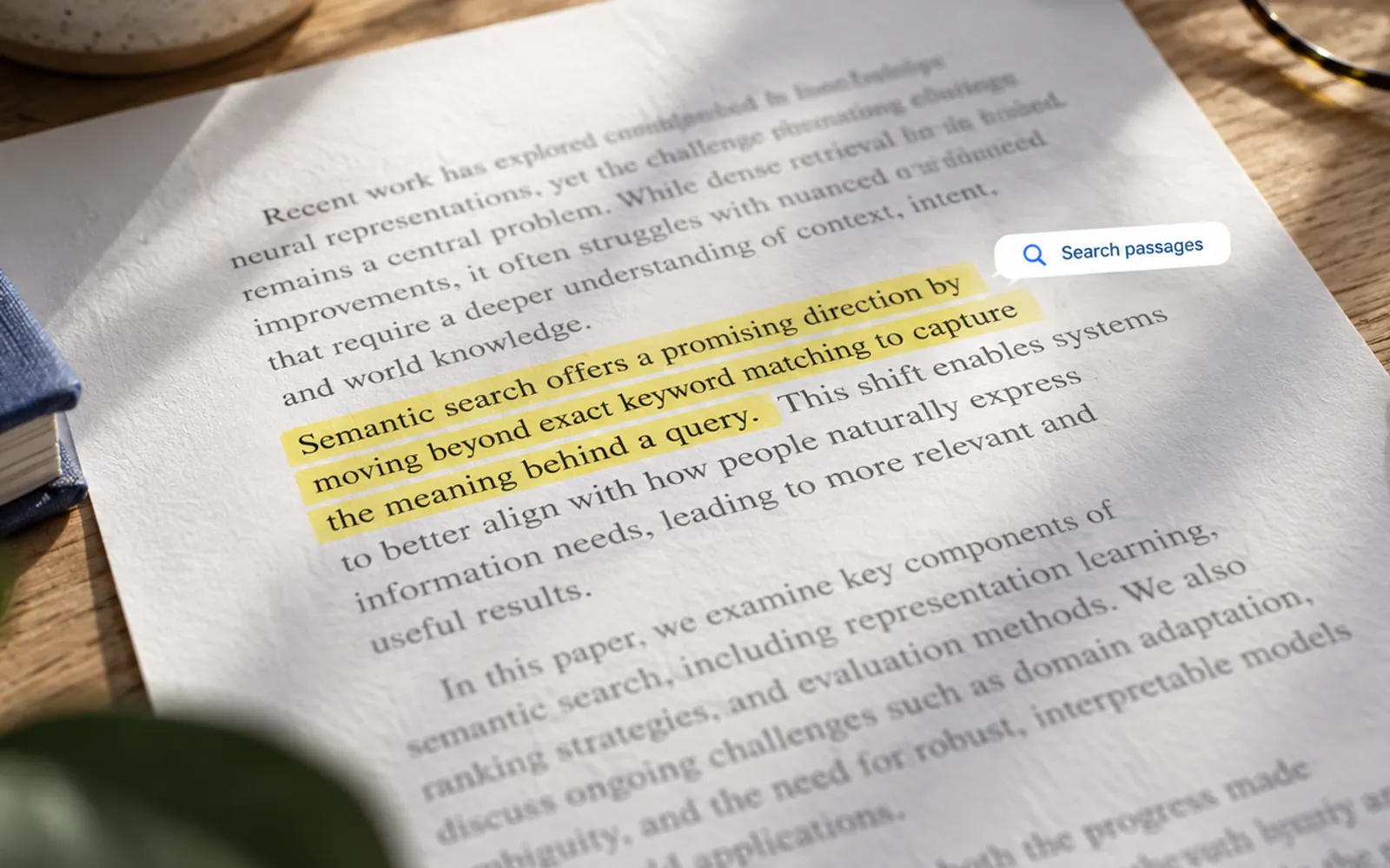 Illustration. A printed page of prose on a desk with one passage picked out in yellow highlighter, and a small search control resting beside it.